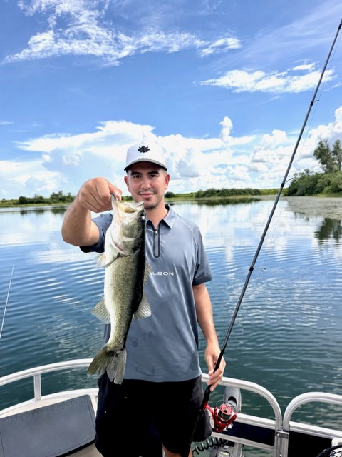 A player fishing from the boat on the lake at Streamsong