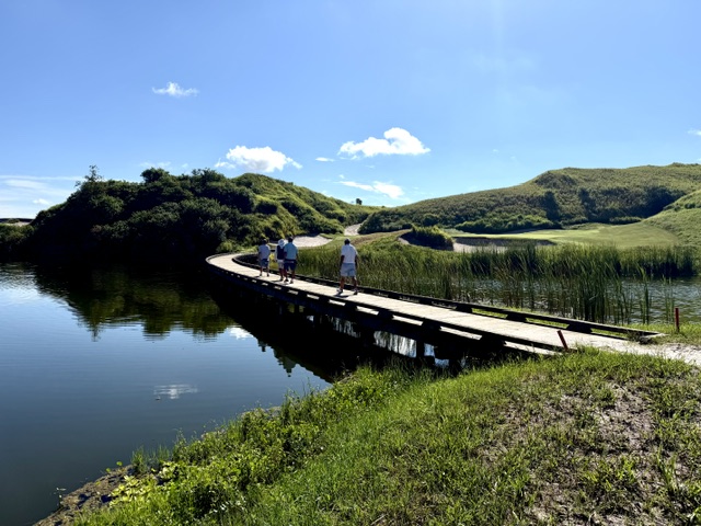 Players crossing the boardwalk between holes
